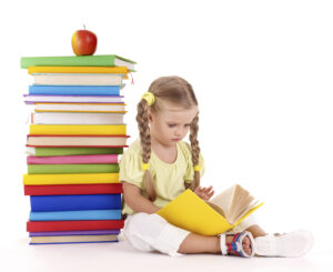 Little girl reading  pile of books. Isolated.